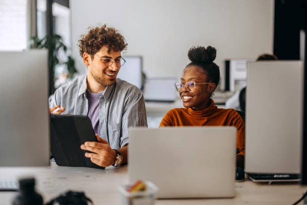 Two young colleagues working together at modern office New opportunities press