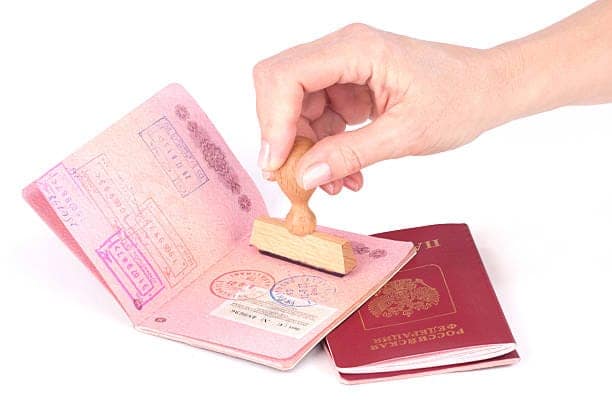 Female hand stamping a passport of Russia over white New opportunities press