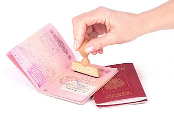 Female hand stamping a passport of Russia over white 40483