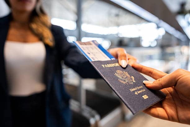 Woman giving her passport to an airline attendant at the airport New opportunities press