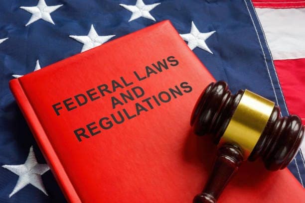 Federal laws and regulations book and a gavel on the flag. New opportunities press